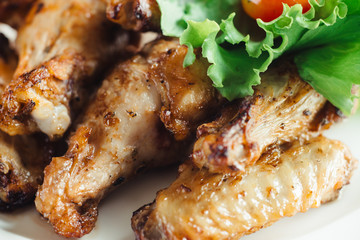 Chicken wings with sauce on plate on wooden table