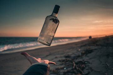 Bottiglia cocktail sospesa per aria in una spiaggia