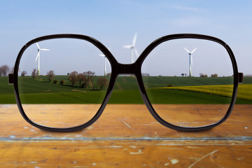 moderne Brille auf Holztisch mit unscharfem Hintergrund