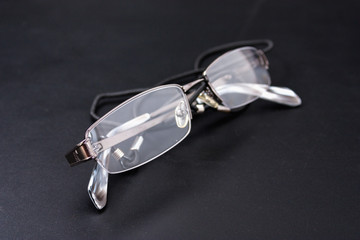Fototapeta na wymiar light reading glasses on a black background