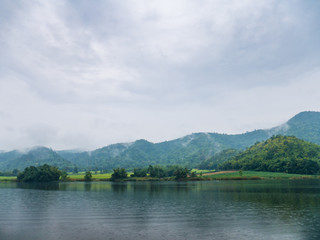 Beautiful tranquil lake and mountain covered with fog