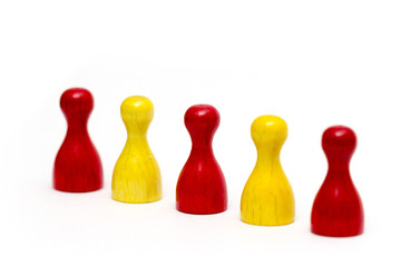 rote und gelbe Holzspielsteine in einer Reihe auf wei&szlig;em Hintergrund