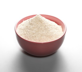 pile whole grain barley flour in bowl isolated on white background