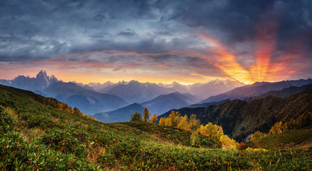 Sunset over snow-capped mountain peaks. The view from the mounta