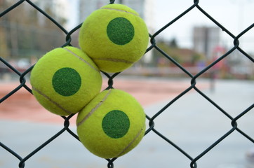 tennis ball in a tennis cort's grating