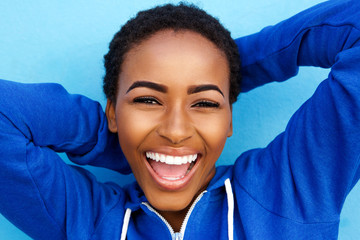 beautiful young black girl laughing with hands behind head