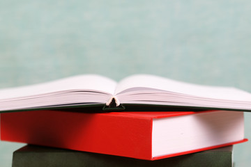 Open book, stack of hardback books. Back to school.