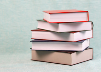Stack of hardback books on blue table. Back to school. Copy spac