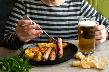 man eating fried sausages and drink beer. Germany, Oktoberfest festival