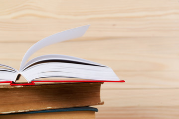 Open book, stack of hardback books. Back to school.