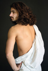 Photo of handsome guy with long curly hair with white drapery is back