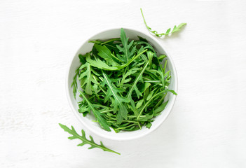 Arugula leaves in a white bowl © fortyforks