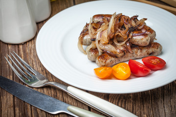 Fried Fried white sausages with onion on the plate.white sausage