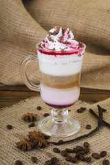 Coffee Latte. Coffee with whipped cream topping  in a tall glass on a wooden background with burlap