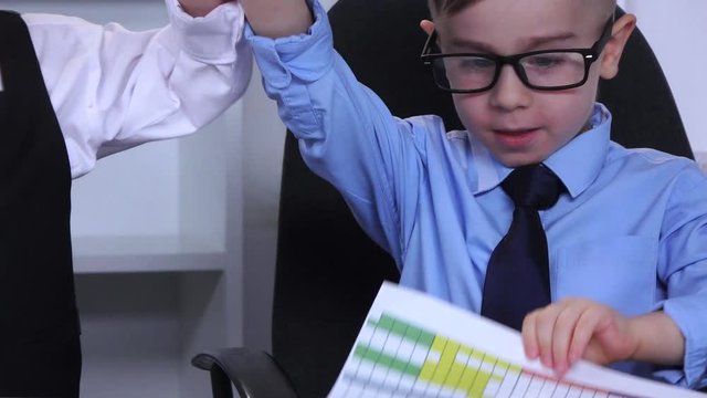 Two boys in the office on the table scatter diagram. Slow motion. Close up