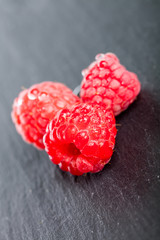 Three fresh juicy wet raspberries