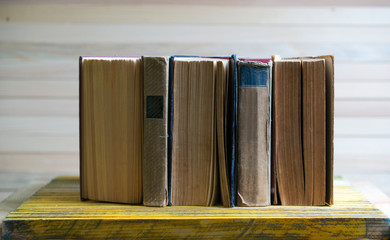 Stack of hardback books on wooden table. Back to school.