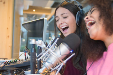 Two beatiful women are singing on the radio - obrazy, fototapety, plakaty