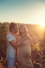 Happy young couple expecting baby, pregnant woman with husband touching belly.