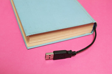 Book with a connector for connection to a computer on a pink bac