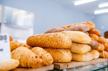 Various kinds of bread on display in bakery shop. Selective focus