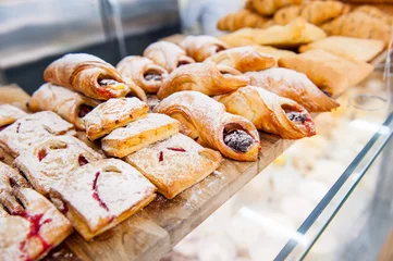 Gordijnen Close-up van vers gebakken gebak goederen tentoongesteld in bakkerij winkel. Selectieve focus © okrasiuk