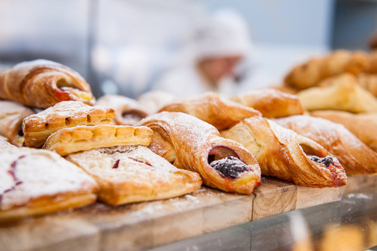 Close up freshly baked pastry goods on display in bakery shop. Selective focus