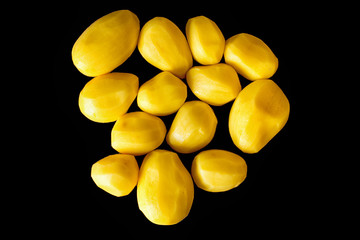 Some peeled raw potatoes on a black background