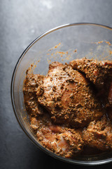 Cooking butter Chicken in a glass bowl on a gray slate