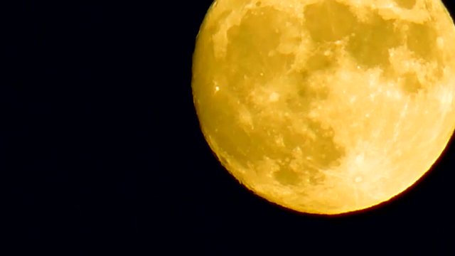 Real video of full moon rising motion in the sky. Mystical view on star. Astronomical survey of planets in night. Astrotheme planet with craters and seas uninhabited land in Universe.