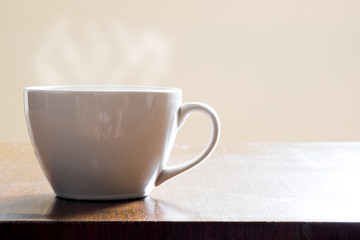 Cup of hot coffee on wooden table