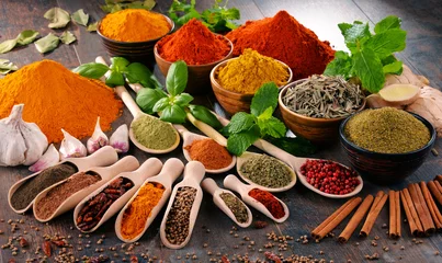 Fotobehang Verscheidenheid aan specerijen en kruiden op keukentafel © monticellllo