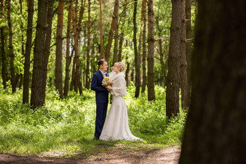 Bride and groom in forest at wedding day