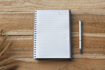 white notebook on wooden desk, top view.