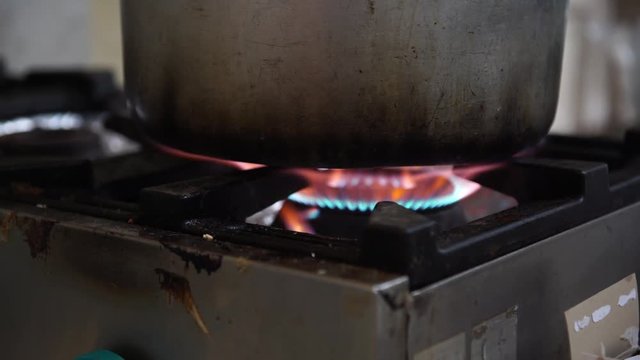 An old dirty cooker with a gas on, selective focus, 4K