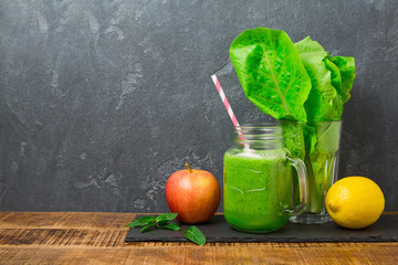 Green smoothie with apple, lettuce and lemon over dark background. Detox, dieting, vegetarian,...