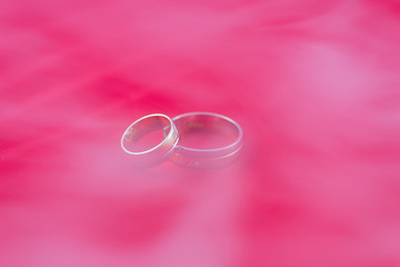 Wedding rings on a red background covered in smoke