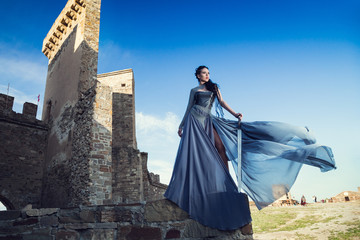 Summer outdoors portrait of beautiful furious scandinavian warrior ginger woman in grey dress with...