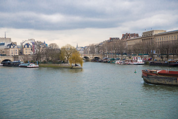 Fototapeta na wymiar Paris, view of the Seine from the pont des Arts, with the Pont-Neuf and a barge crossing 