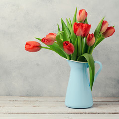 Red tulip flowers bouquet over rustic background