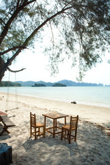 Fototapeta na wymiar table et chaises sur une belle plage paradisiaque