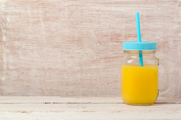 Orange juice in mason jar over wooden background with copy space. Healthy eating or dieting concept