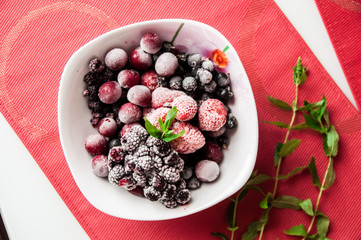 Frozen berries on plate with a bunch of mint