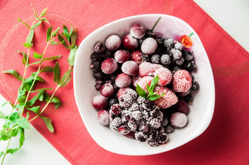 frozen berries on white squareplate with bunch of mint