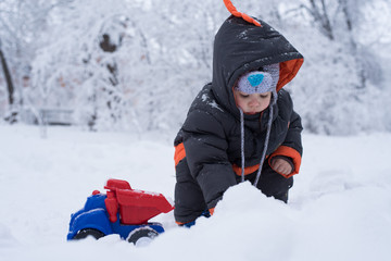 Fototapeta na wymiar Little boy playing with snow