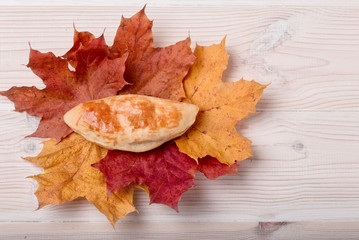 Naklejka na ściany i meble Russian pie in the autumn leaves on a light wooden background
