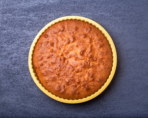 Fresh homemade round a cake on a gray background. It looks like