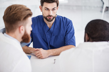 Serene physician telling with affiliates at conference