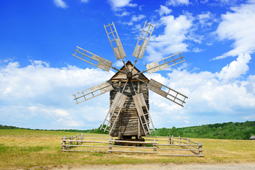 Fototapeta na wymiar Old wooden windmill against the sky.
