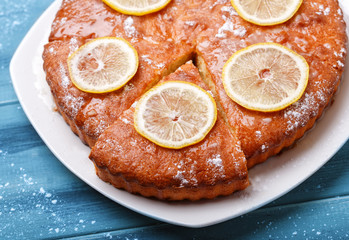 A slice of fresh pie with lemon sprinkled with powdered sugar an